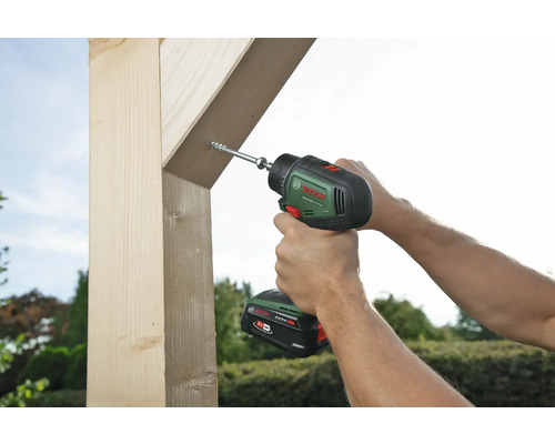 Une personne visse une vis dans une pièce de bois avec une visseuse sans fil.