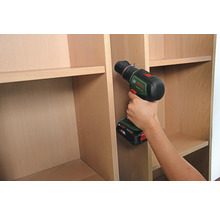 Une personne utilise une perceuse sans fil pour assembler une étagère.