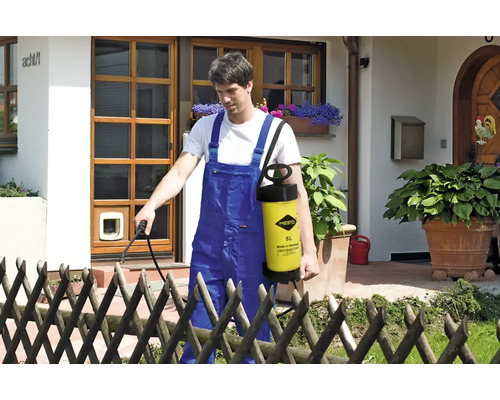 Un homme utilise un pulvérisateur de jardin Mesto pour jardiner devant une maison.