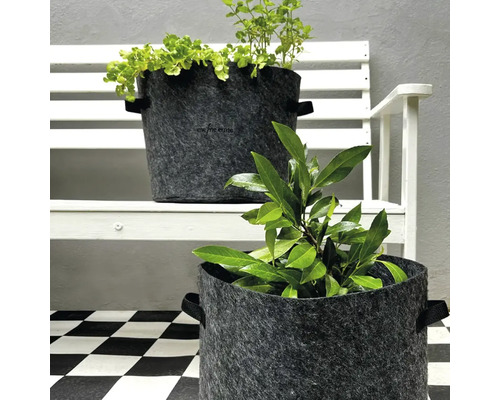 Deux bacs à plantes en feutre avec des plantes sur un banc