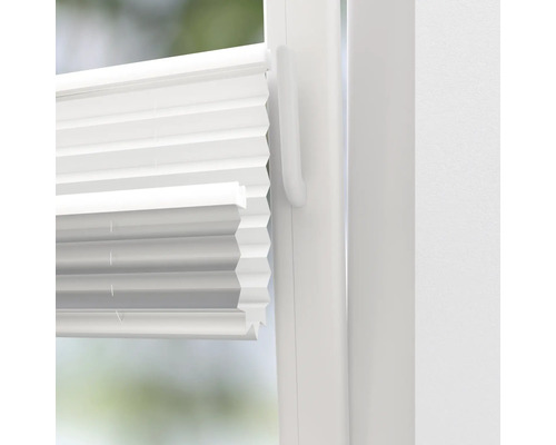 Vue détaillée d''un store plissé blanc sur une fenêtre