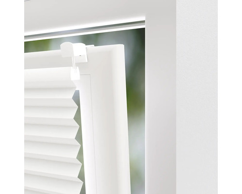 Gros plan d''un store plissé blanc sur une fenêtre