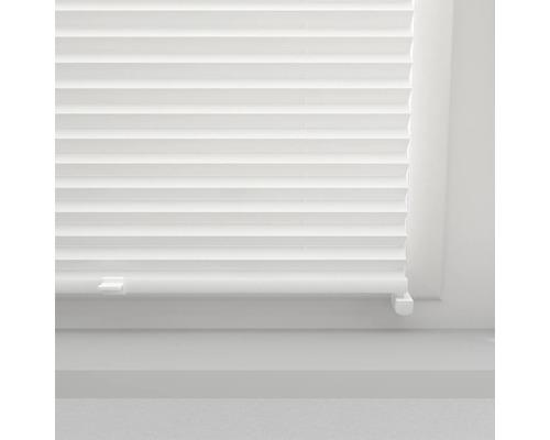 Gros plan d''un store plissé blanc sur une fenêtre