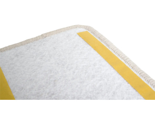 Vue détaillée d'une dalle de moquette avec des bandes adhésives à l'arrière.