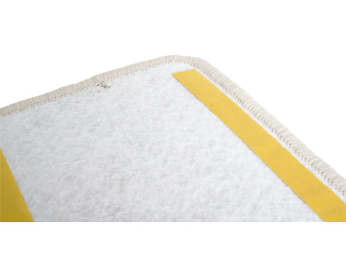 Gros plan sur l'envers d'un tapis avec des bandes adhésives pour la fixation.