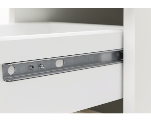 Detailaufnahme eines Schubladenauszugs aus Metall an einem weißen Möbelstück