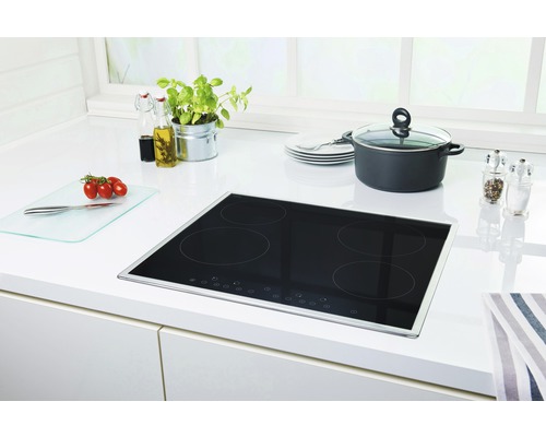 Induktionskochfeld in einer hellen Küche mit Kochutensilien.