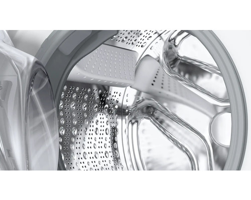 Vue intérieure d''un tambour de machine à laver en acier inoxydable avec des trous.