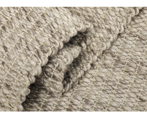 Nahaufnahme eines hellen Teppichs mit grober Webstruktur