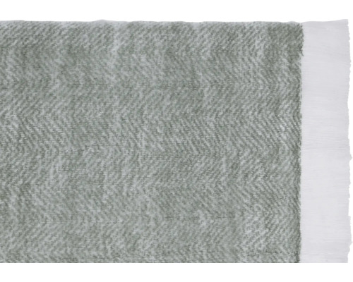 Gros plan d''un couvre-lit gris avec motif à chevrons et franges