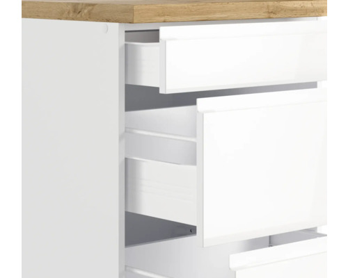 Detailaufnahme eines weißen Schubladenschranks mit Holzplatte und geöffneten Schubladen