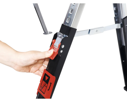 Detailansicht einer Arbeitsbühne mit Hand, die den roten Sicherheitsverschluss betätigt