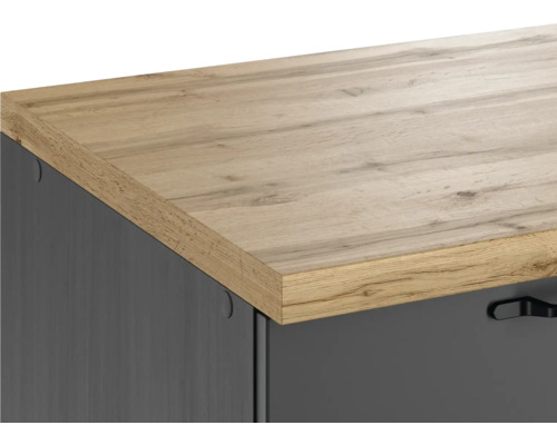 Detailaufnahme eines Möbelstücks mit Holzplatte und dunkler Front