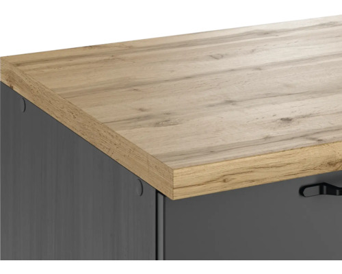 Detailansicht eines Möbels mit einer Arbeitsplatte in Holzoptik und einer grauen Schublade