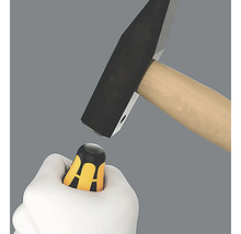 Un marteau frappe un tournevis dans une main