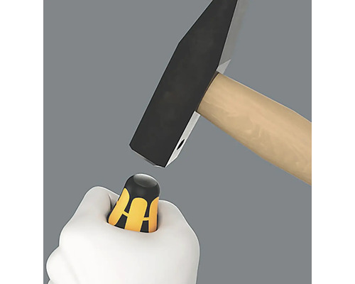 Un marteau frappe un tournevis dans une main