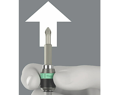 Un embout de tournevis cruciforme avec un marquage blanc, tenu par une main.
