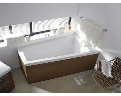 Salle de bain moderne avec baignoire, serviettes et chaise