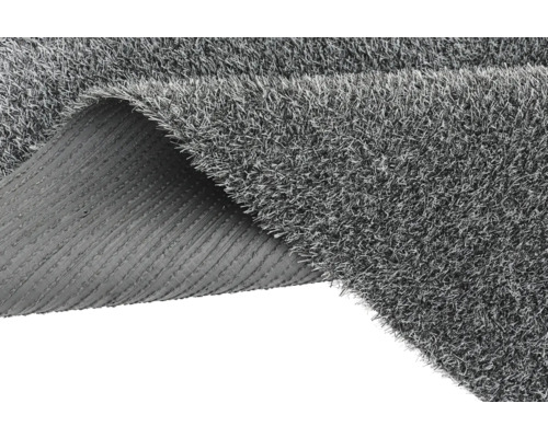 Gazon synthétique gris avec un coin enroulé montrant le dos