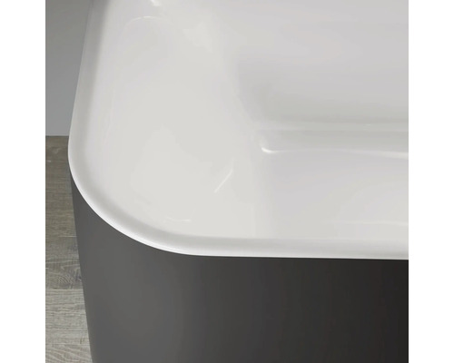 Detailansicht einer Badewanne mit grauer Verkleidung und weißem Innenraum