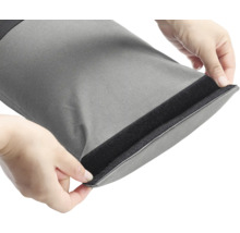 Sac gris avec fermeture velcro ouvert par des mains.