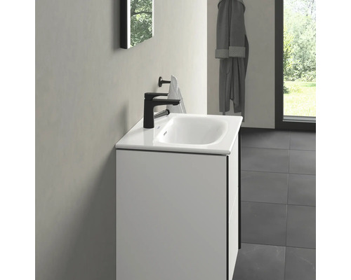 Meuble-lavabo avec robinet noir et porte-serviettes dans la salle de bain