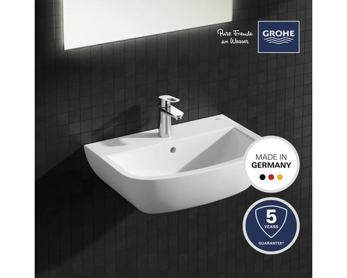 Keramikwaschbecken mit Armatur vor dunklem Fliesenhintergrund, Gütesiegel Made in Germany, Grohe Logo, fünf Jahre Garantie