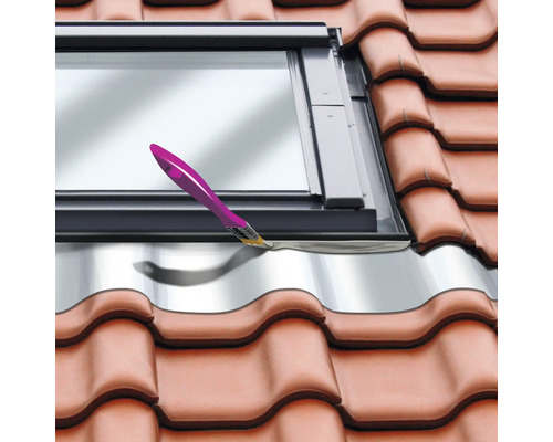 Gros plan d''une fenêtre de toit installée dans un toit en tuiles. Un pinceau est visible.