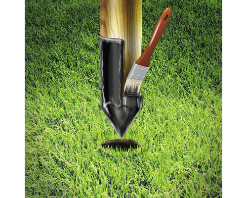 Pfosten mit Teer-Anstrich und Pinsel auf Rasen