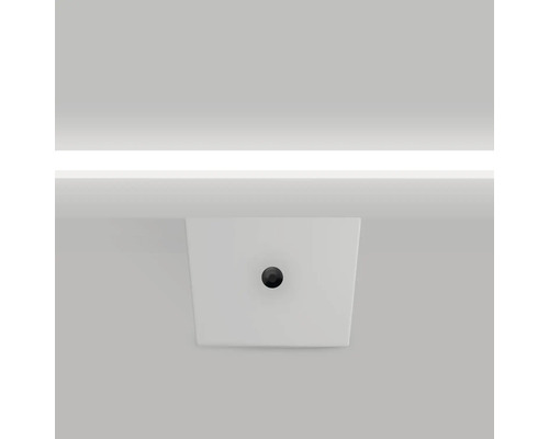 Ein weisses Aufsatzwaschbecken mit einem runden, dunklen Abflussstopfen.