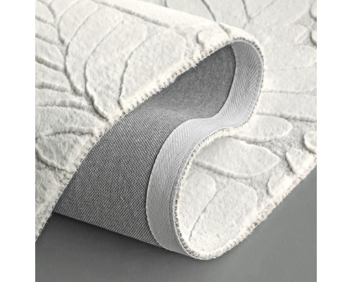 Tapis blanc à motif de feuilles, présenté enroulé