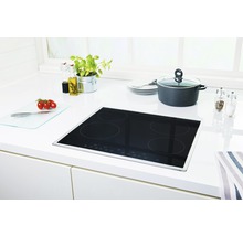 Plaque à induction dans une cuisine lumineuse avec casserole, épices et ingrédients