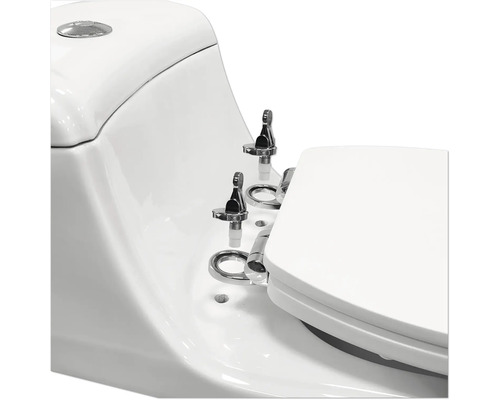 Gros plan de toilettes blanches avec ferrures chromées