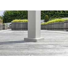 Vue détaillée d''une lame de terrasse avec une base de poteau blanche dans le jardin
