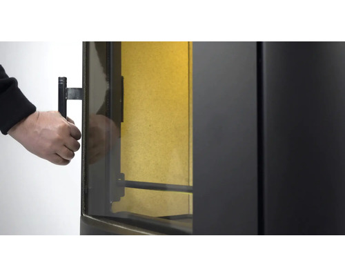 Detailansicht eines Kaminofens beim Öffnen der Tür