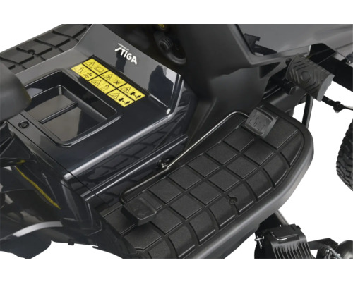 Detailaufnahme eines Rasentraktors mit Fusspedal und Warnhinweisen