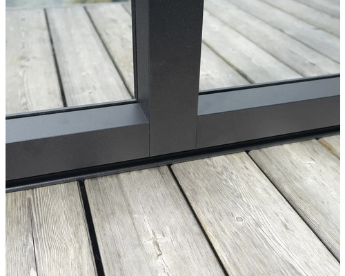 Detailansicht eines schwarzen Fensterrahmens auf einer Holzterrasse