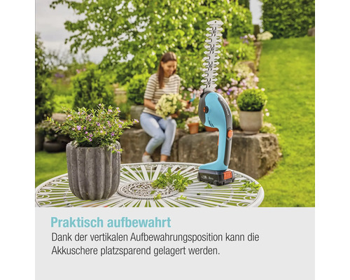 Cisailles à gazon et à arbustes sans fil sur une table de jardin avec une femme en arrière-plan