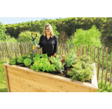 Jardinière en bois avec légumes et femme tenant une bêche