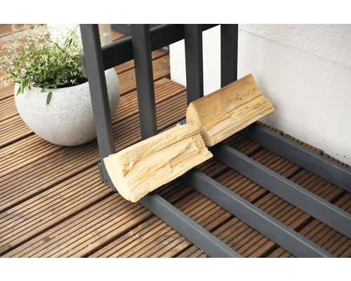 Brennholzregal mit Holz und Topfpflanze auf einer Terrasse