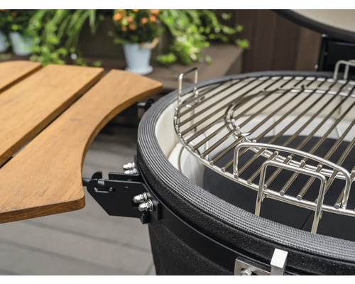 Detailaufnahme eines Keramikgrills mit Grillrost und Seitentisch