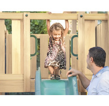 Fille sur un toboggan en bois avec son père dans le jardin.
