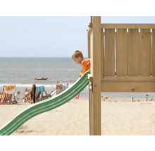 Enfant sur un toboggan dans une aire de jeux de plage
