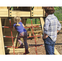Une fille grimpe sur une aire de jeux avec une structure en filet pendant qu''une femme regarde.