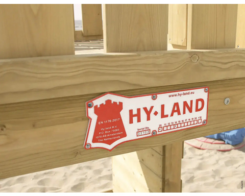Hy-Land Herstellerplakette an einem Spielgerät aus Holz.