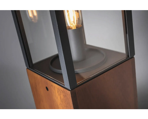 Gros plan d''un luminaire de chemin avec insert en verre et éléments en bois