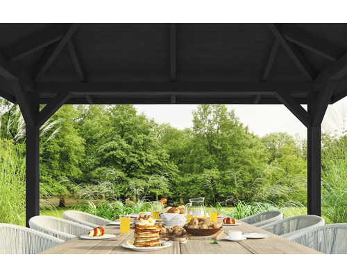 Scène de jardin sous une pergola en bois avec une table dressée et vue sur le jardin