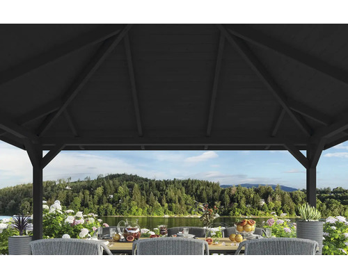 Scène sous un pavillon avec une table mise et vue sur un lac