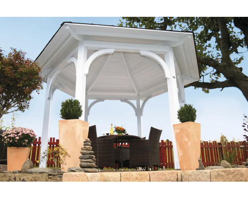 Pavillon de jardin blanc avec table et chaises dans le jardin.