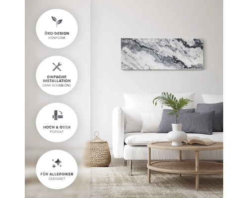 Salon avec canapé, table et tableau mural avec design écologique, installation facile grâce au gabarit, convient aux formats portrait et paysage et aux personnes allergiques.